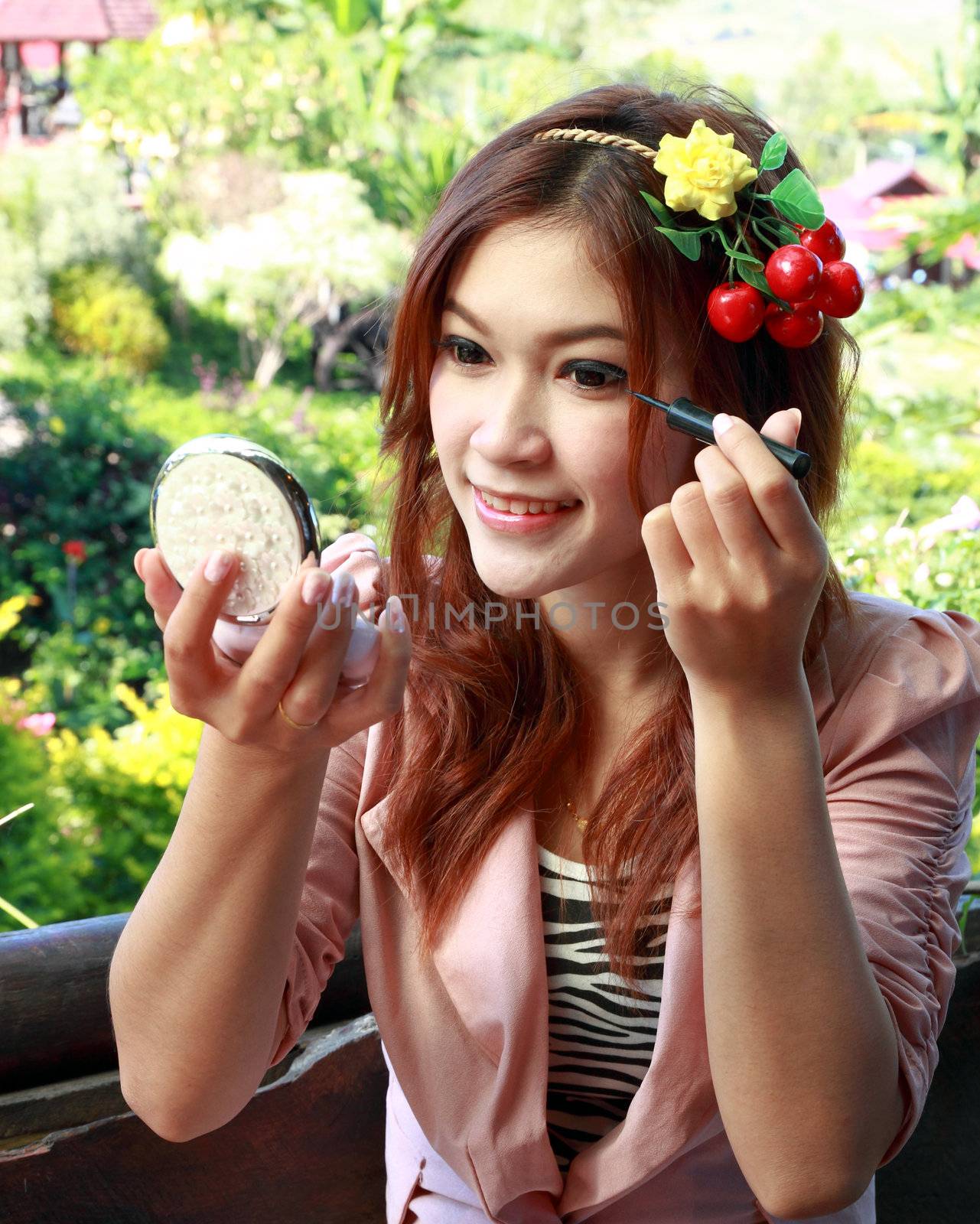 beautiful asian woman applying make up
