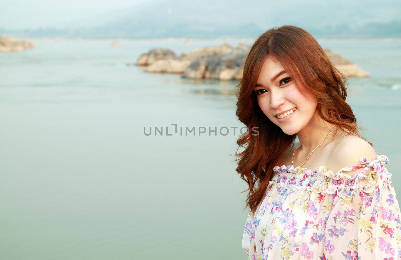 a portrait of beautiful woman with river background