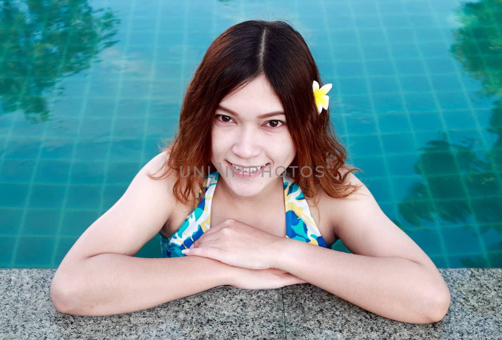Closeup of beautiful woman resting on the edge of swimming pool by geargodz
