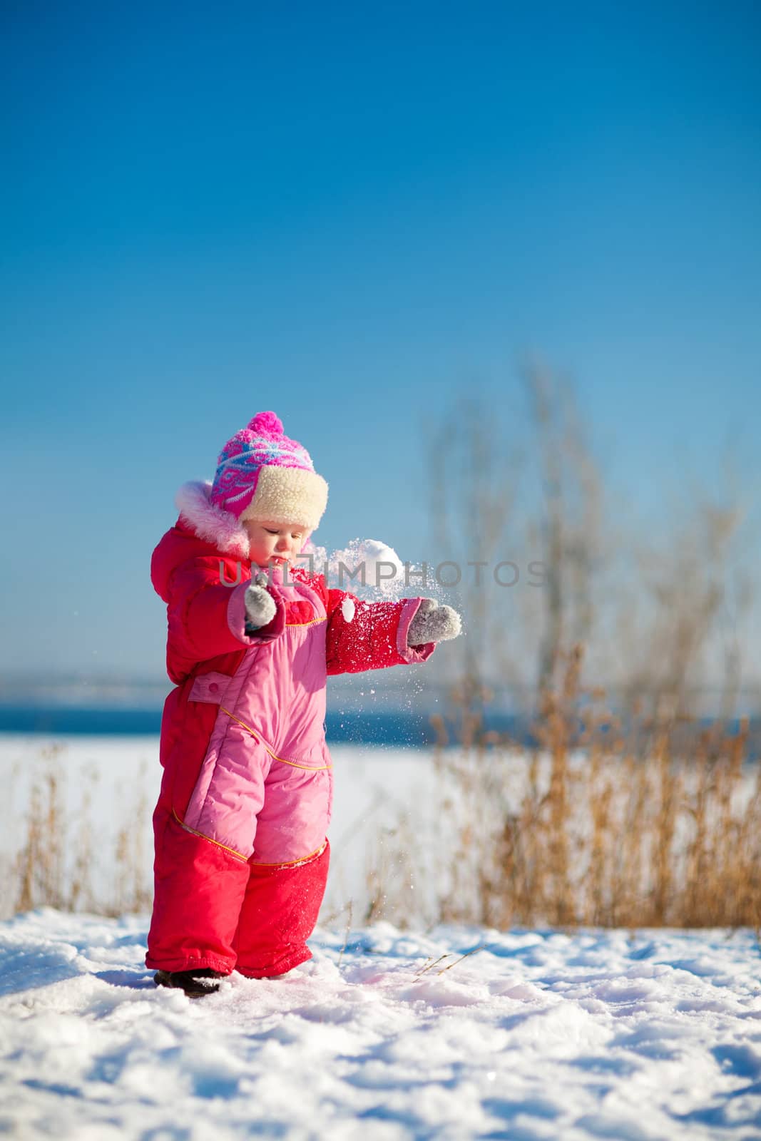 small child throwing snow in winter