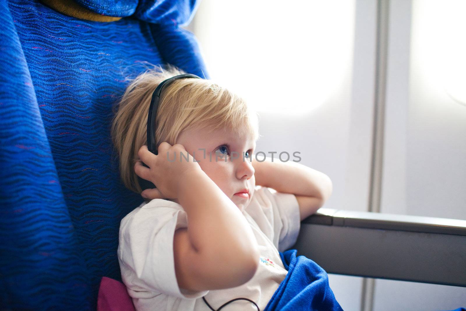 child with headphones in the plane by vsurkov