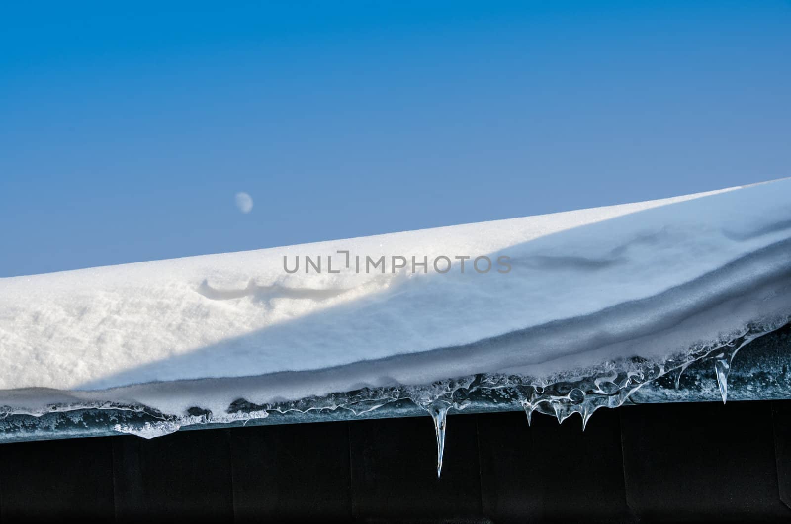 snow and icicle at a roof in winter