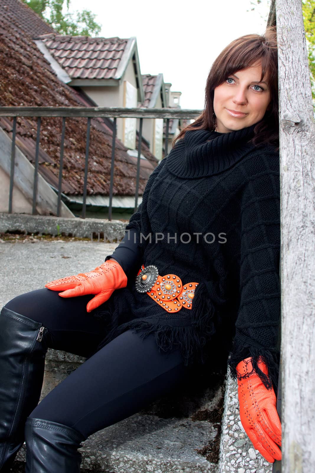 Beatiful smilling red gloved girl sitting on the stears