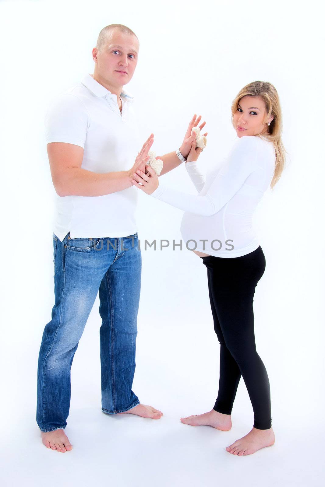 Happy prospective parents with self-made child's boots smiling. 