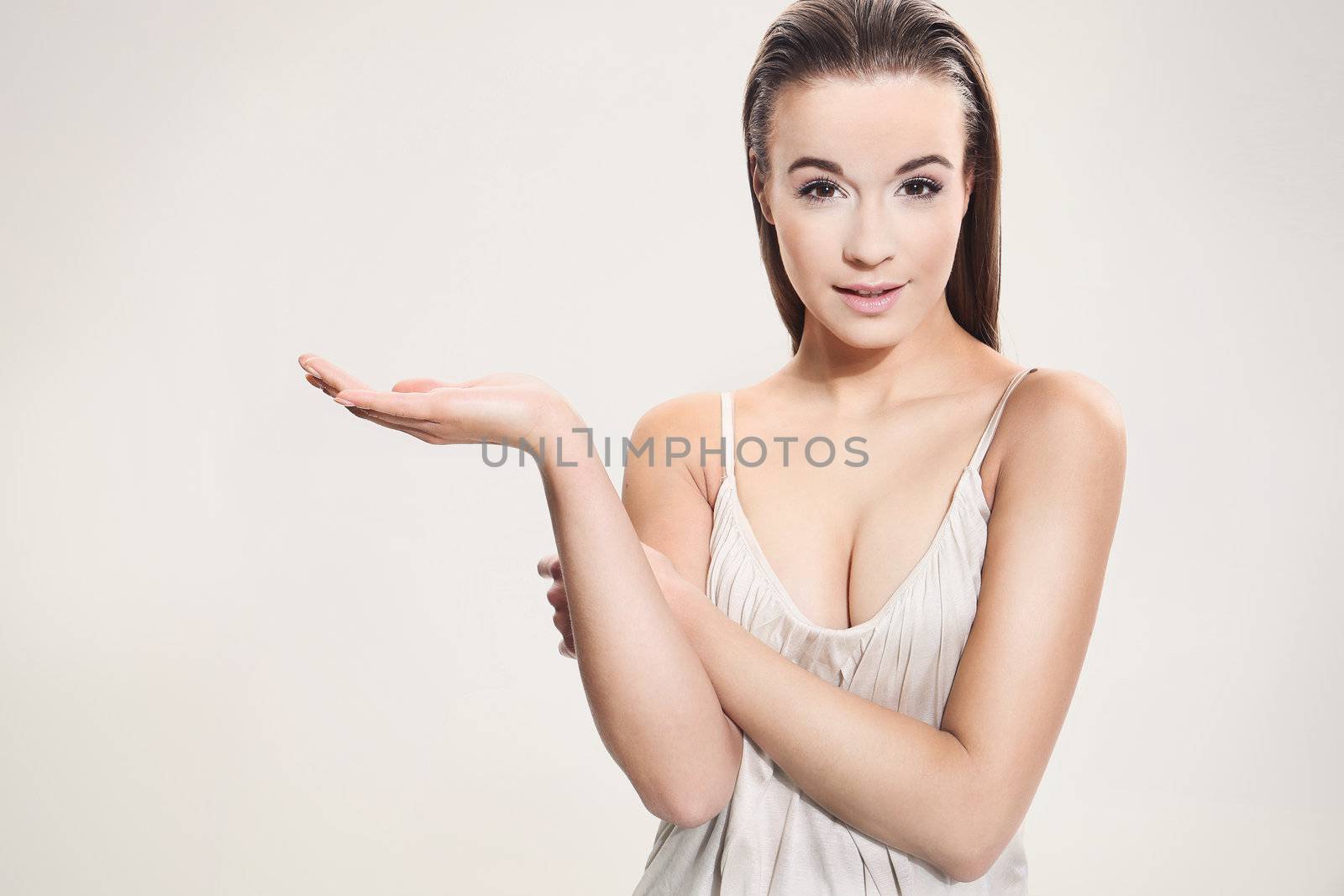 Beautiful girl shows a sign on a white background