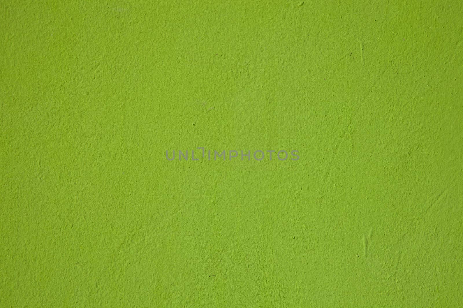 A light shade of lime green paint on a rendered surface.