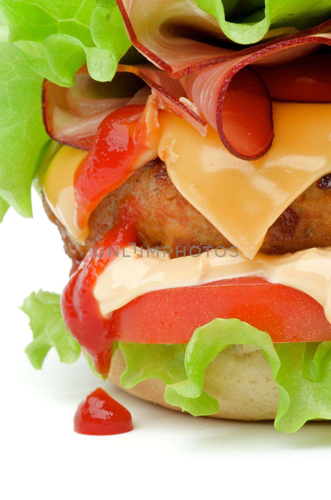 Tasty Juicy Hamburger with Bacon, Beef, Cheese, Tomato, Lettuce, Mayonnaise and Drop of Ketchup closeup on white background