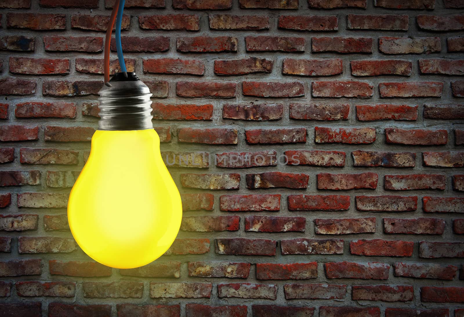 Yellow light bulb and wall background.