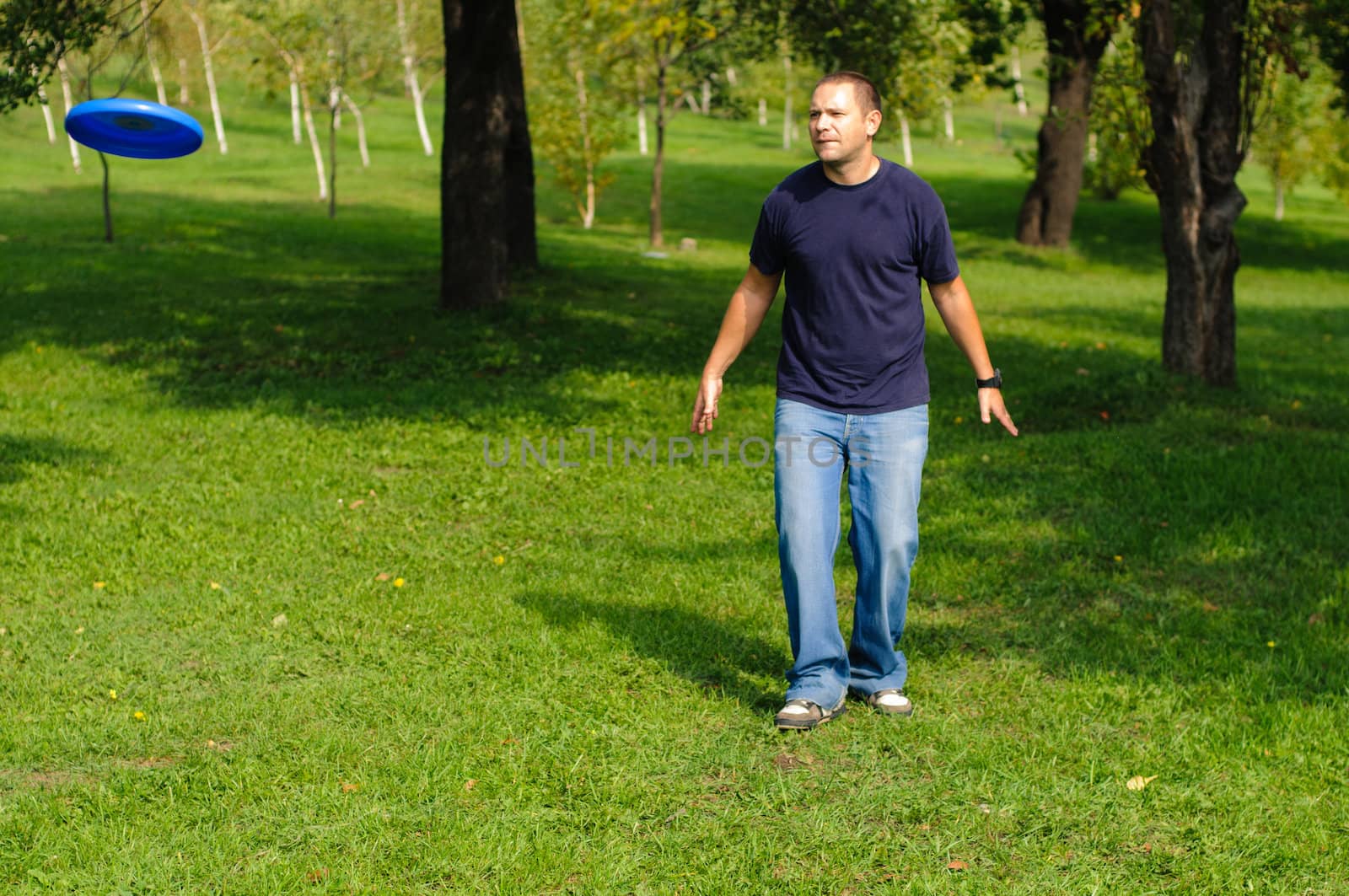 Young man playing frisbee on green grass