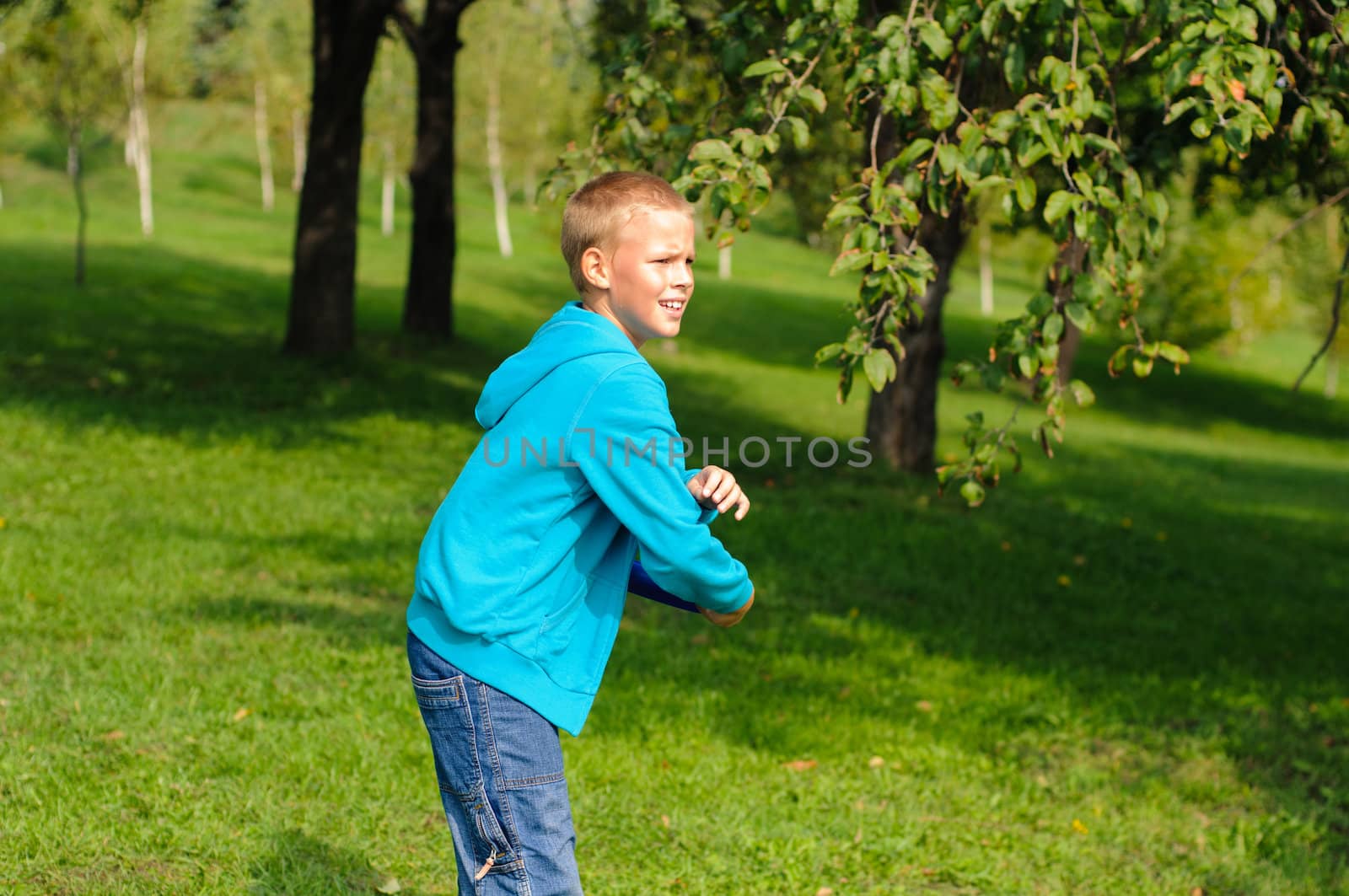 Little boy playing frisbee on green grass