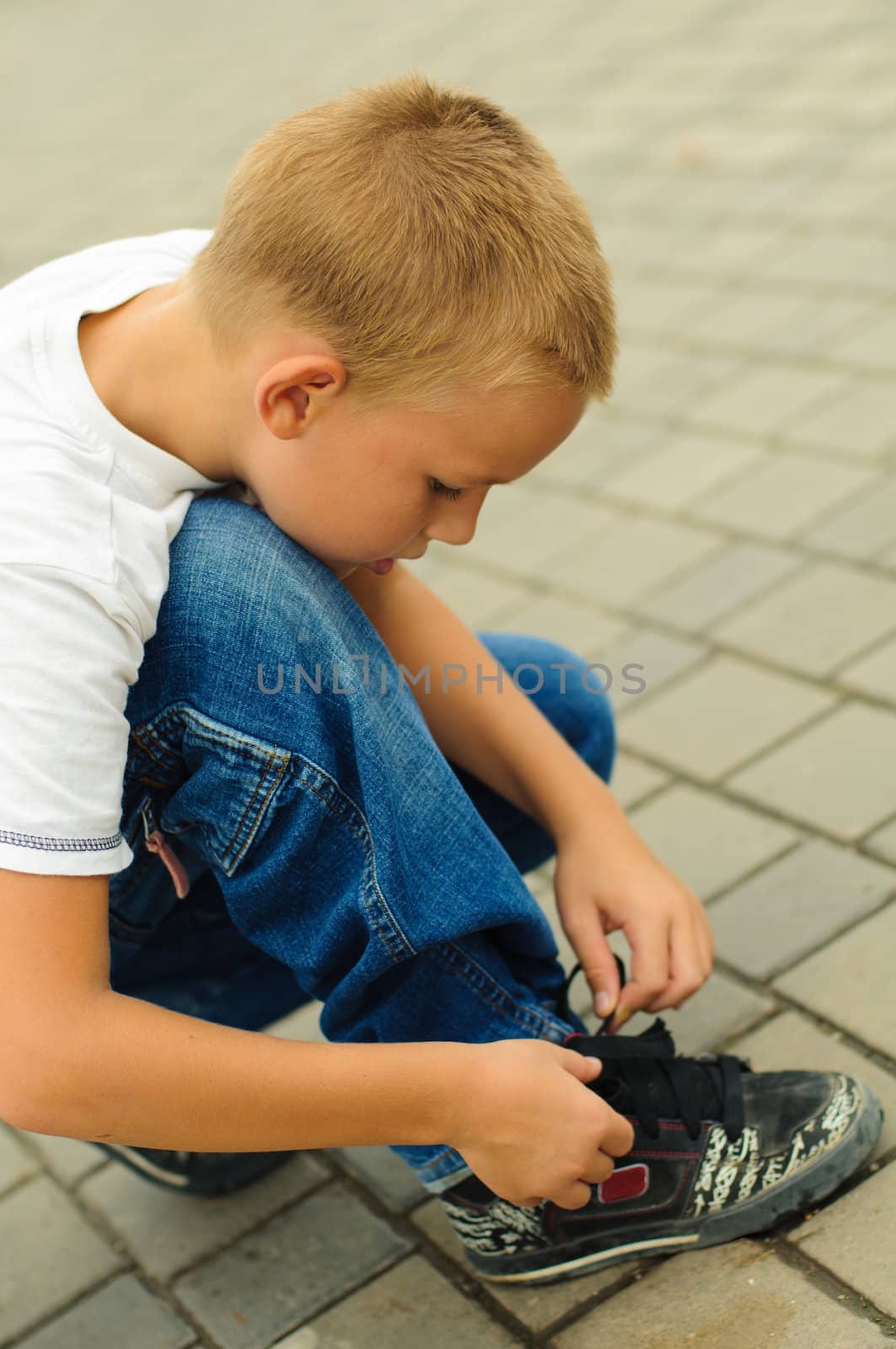 Boy tying the laces on his sneakers