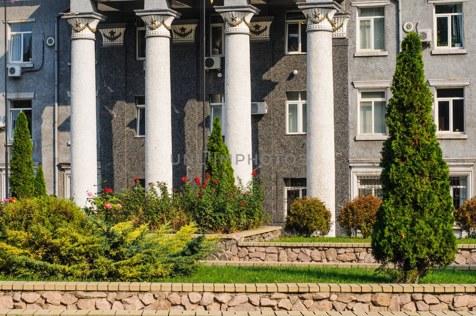 Image of old fashioned building with columns and pine tree