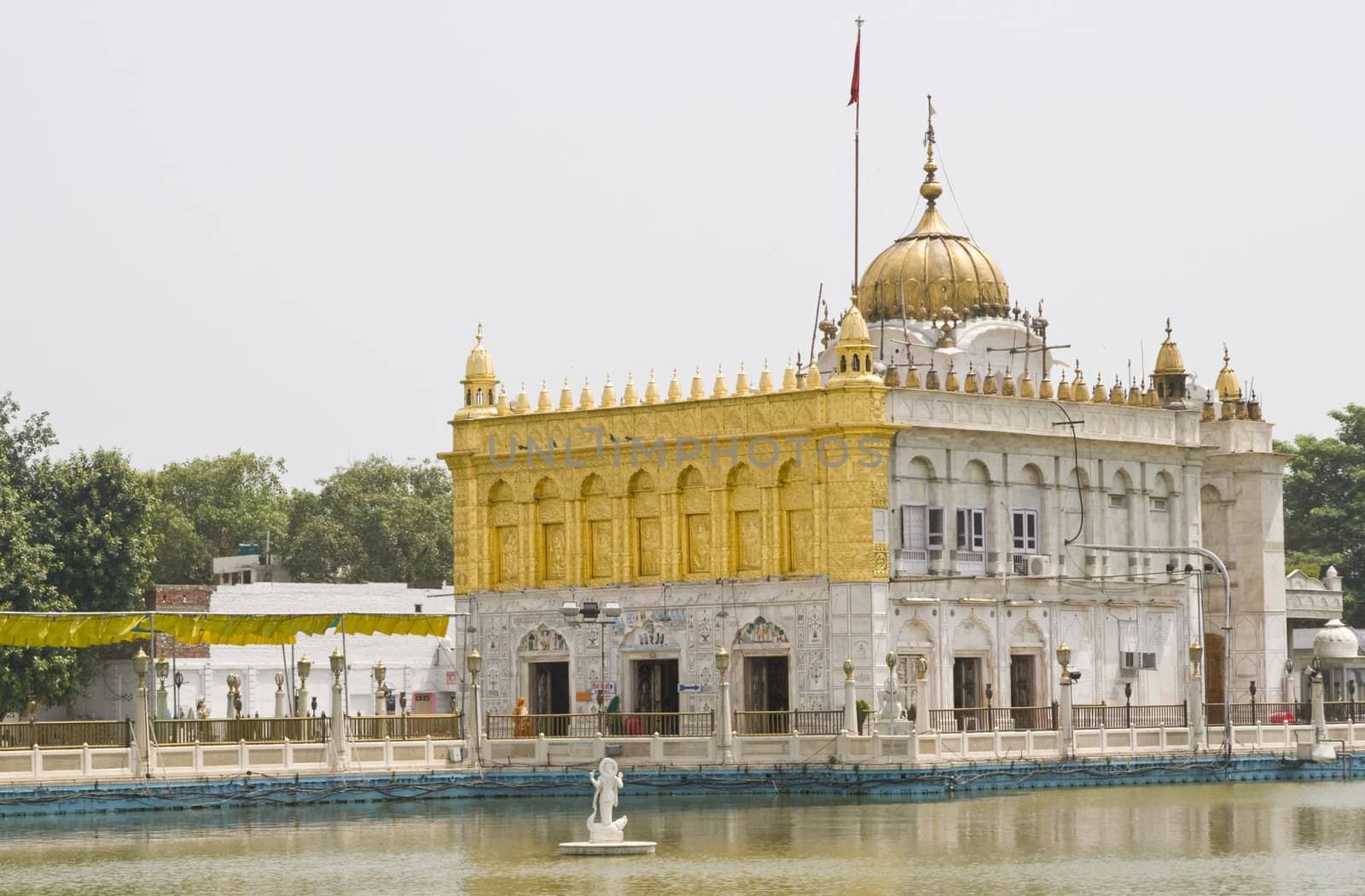 Durgiana Hindu Temple. White marble building with gold dome set in artificial lake. Amritsar, Punjab, India