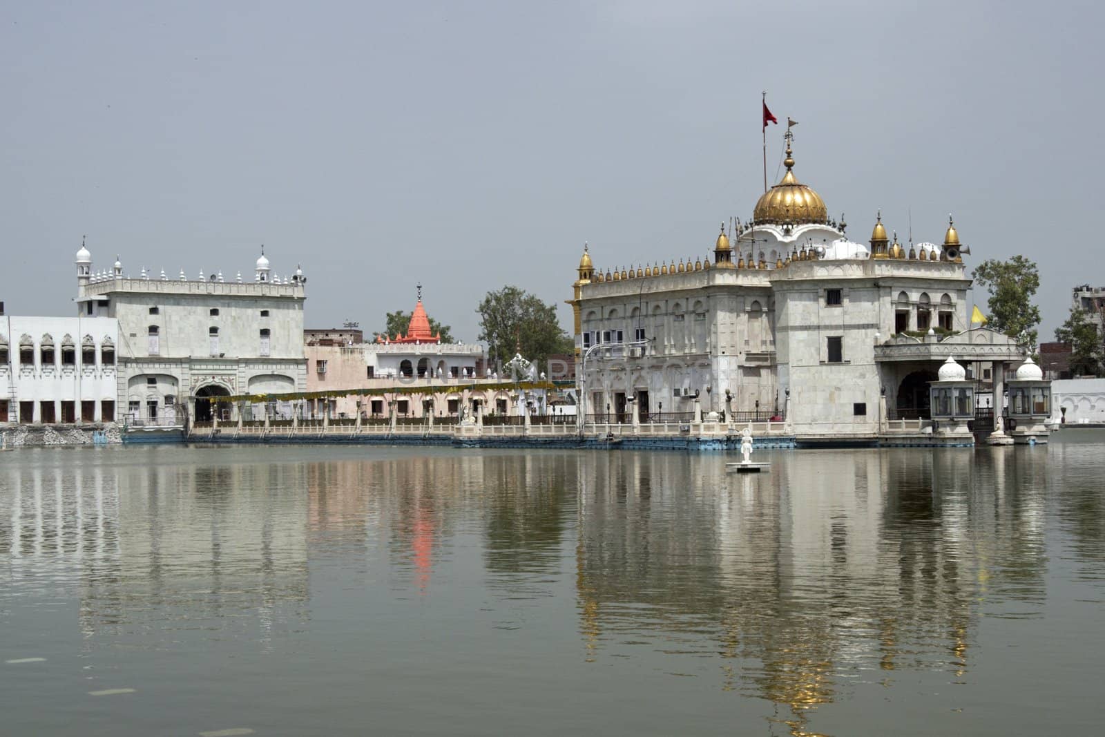 Durgiana Hindu Temple. White marble building with gold dome set in artificial lake. Amritsar, Punjab, India