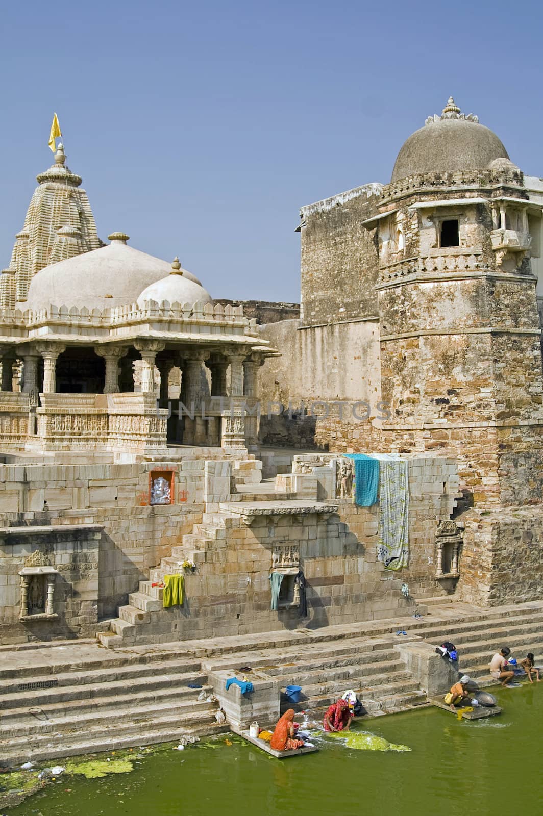 Indian women washing clothes in the lake of a derelict palace (Pratap Palace) inside Chittaugarh Fort in Rajasthan, India