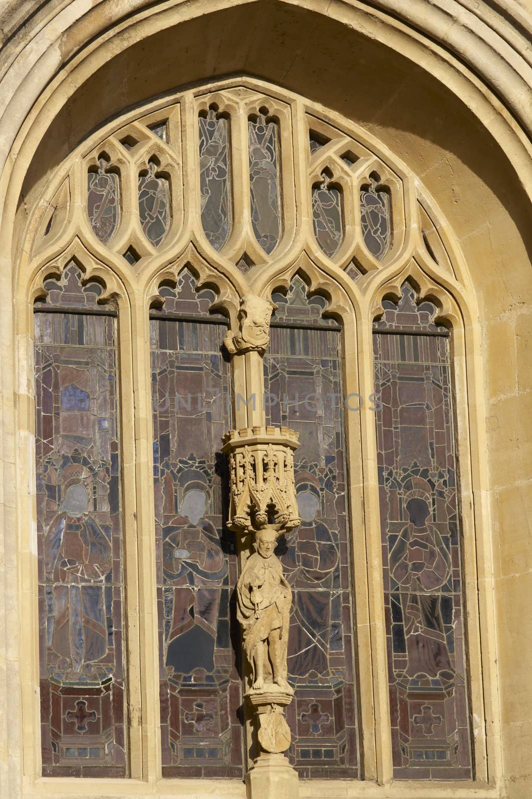 Stain glass window and religious statue decorating historic Bath Abbey in Bath, Somerset, England. Historic Georgian style building built of locally mined bath stone.