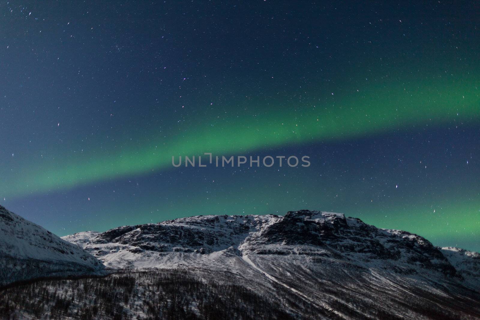 Northern Lights (Aurora Borealis) behind mountains by jamenpercy