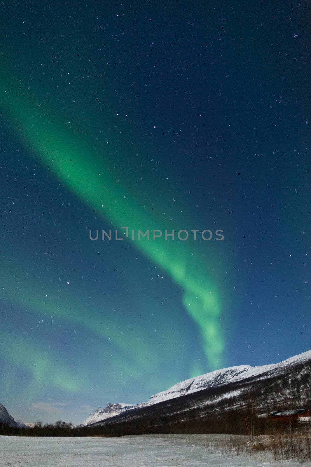 Northern Lights (Aurora Borealis) behind mountains by jamenpercy