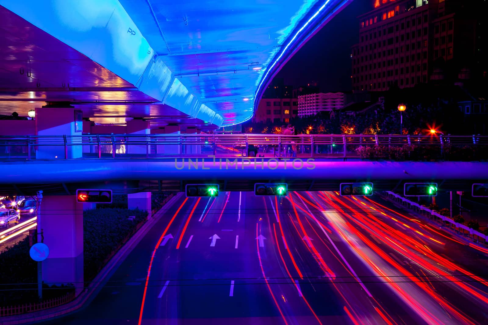 Blue Highway Street Traffic Cars and Green Traffic Light Red Light Trails at Night in Central Shanghai, China.