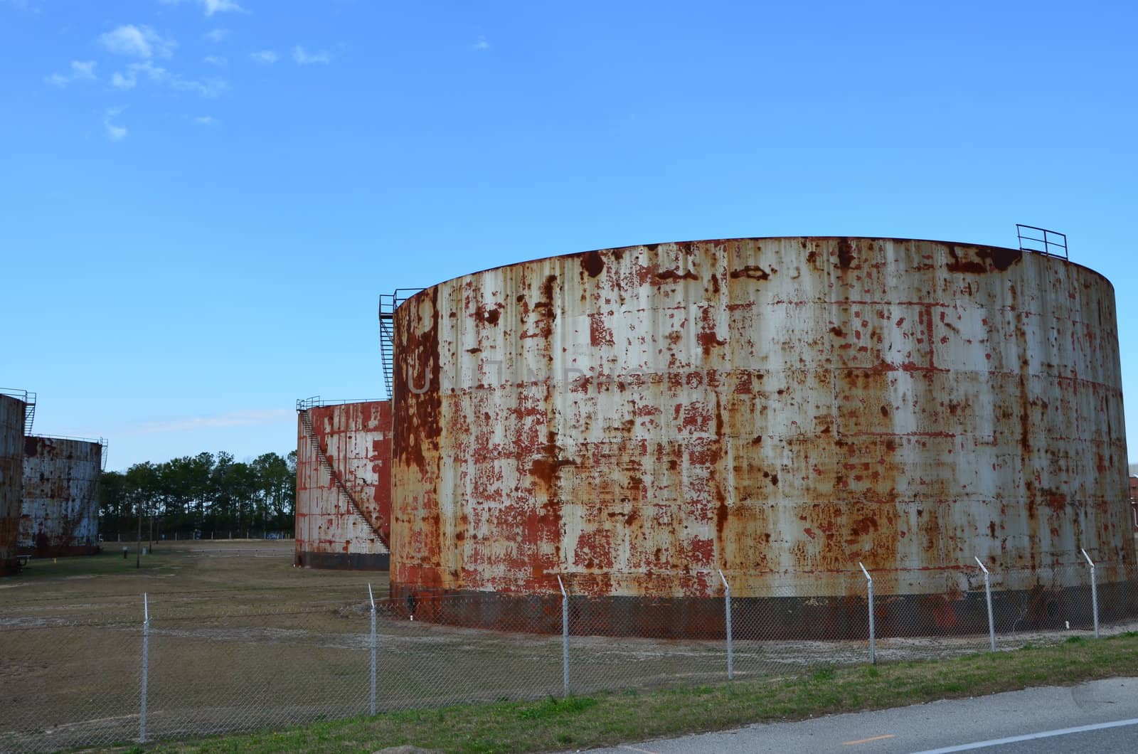 Rusted oil storage tanks shown up close.