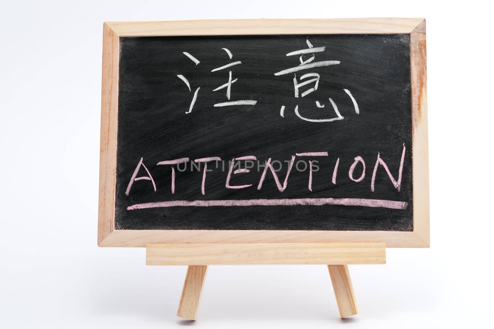 Bilingual word of Attention in both Chinese and English written on blackboard over white background