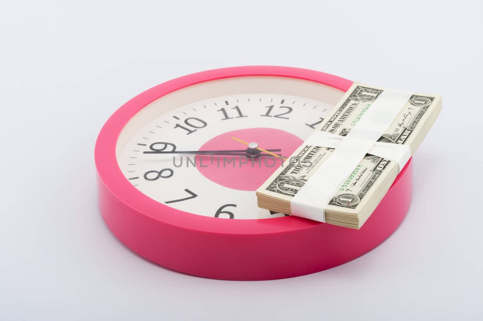 Clock and a stack of paper money on white background