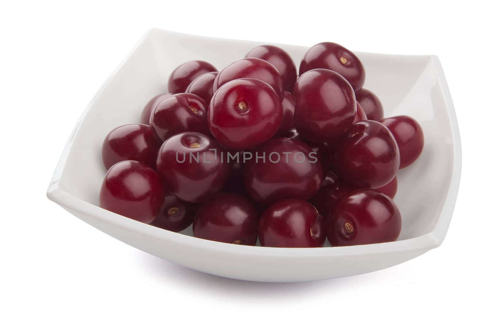 Some red cherries in the white plate