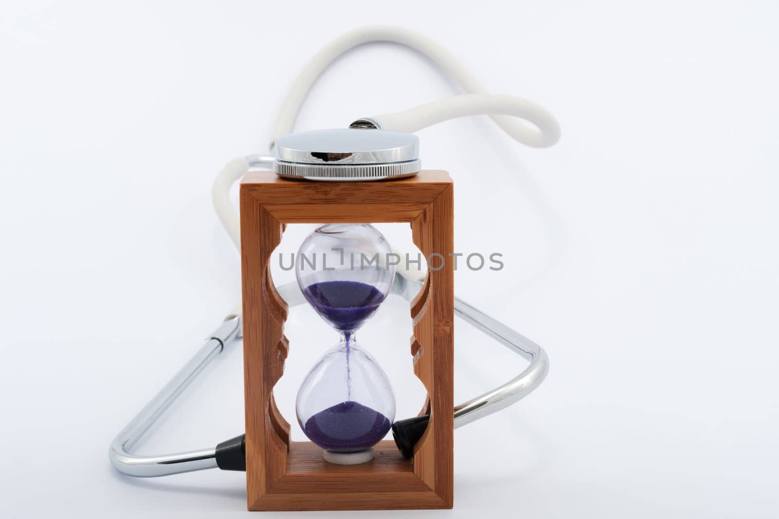 Using stethoscope with hourglass on white background