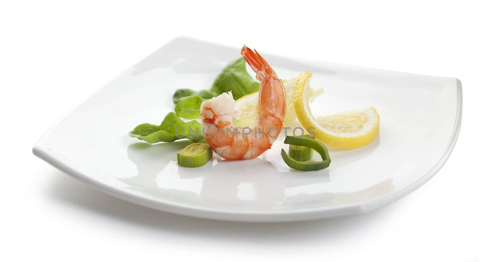 One boiled shrimp's tail with  lettuce, leek and lemon on the white plate