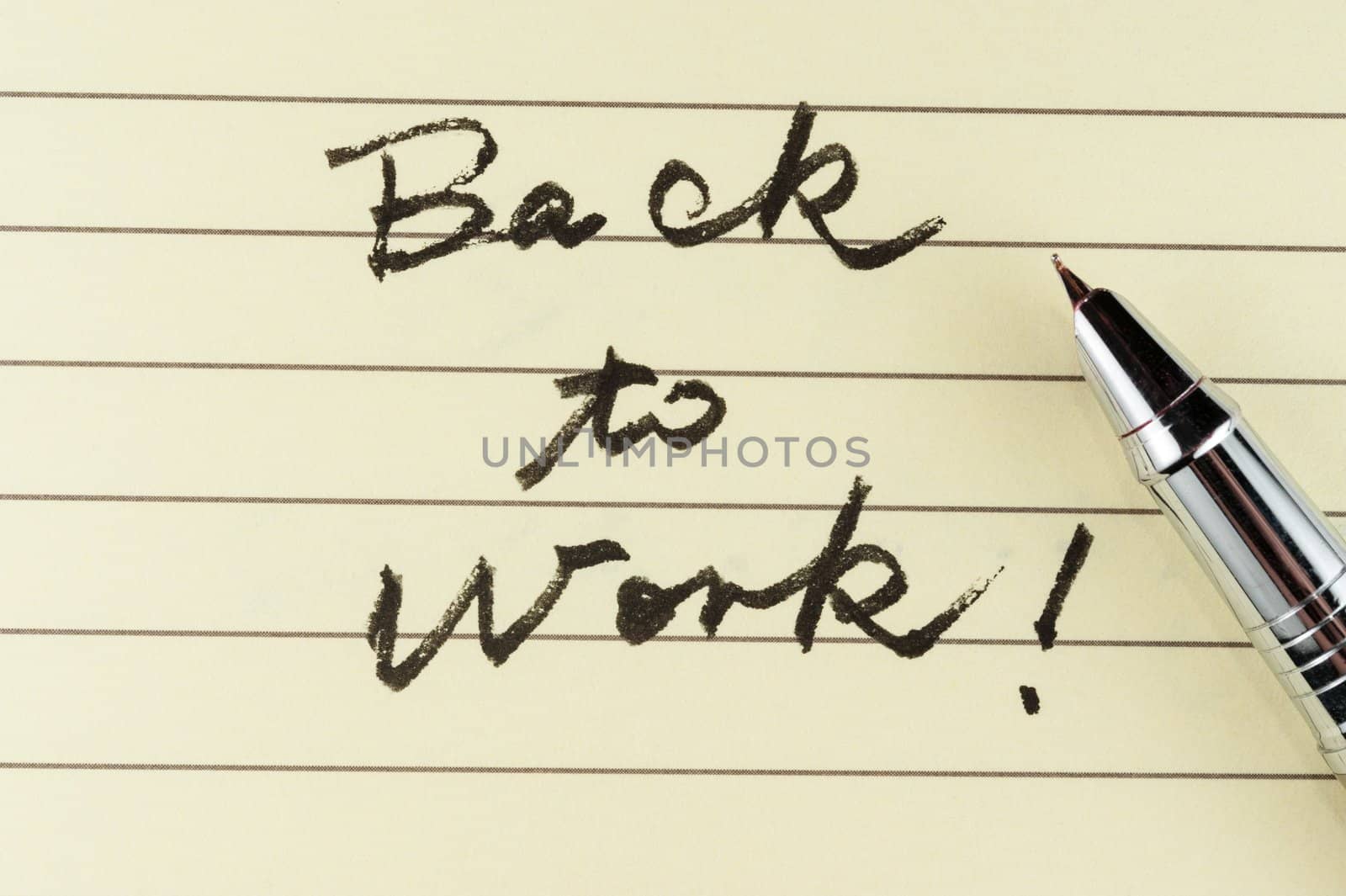 Back to work words written on lined paper with a pen on it