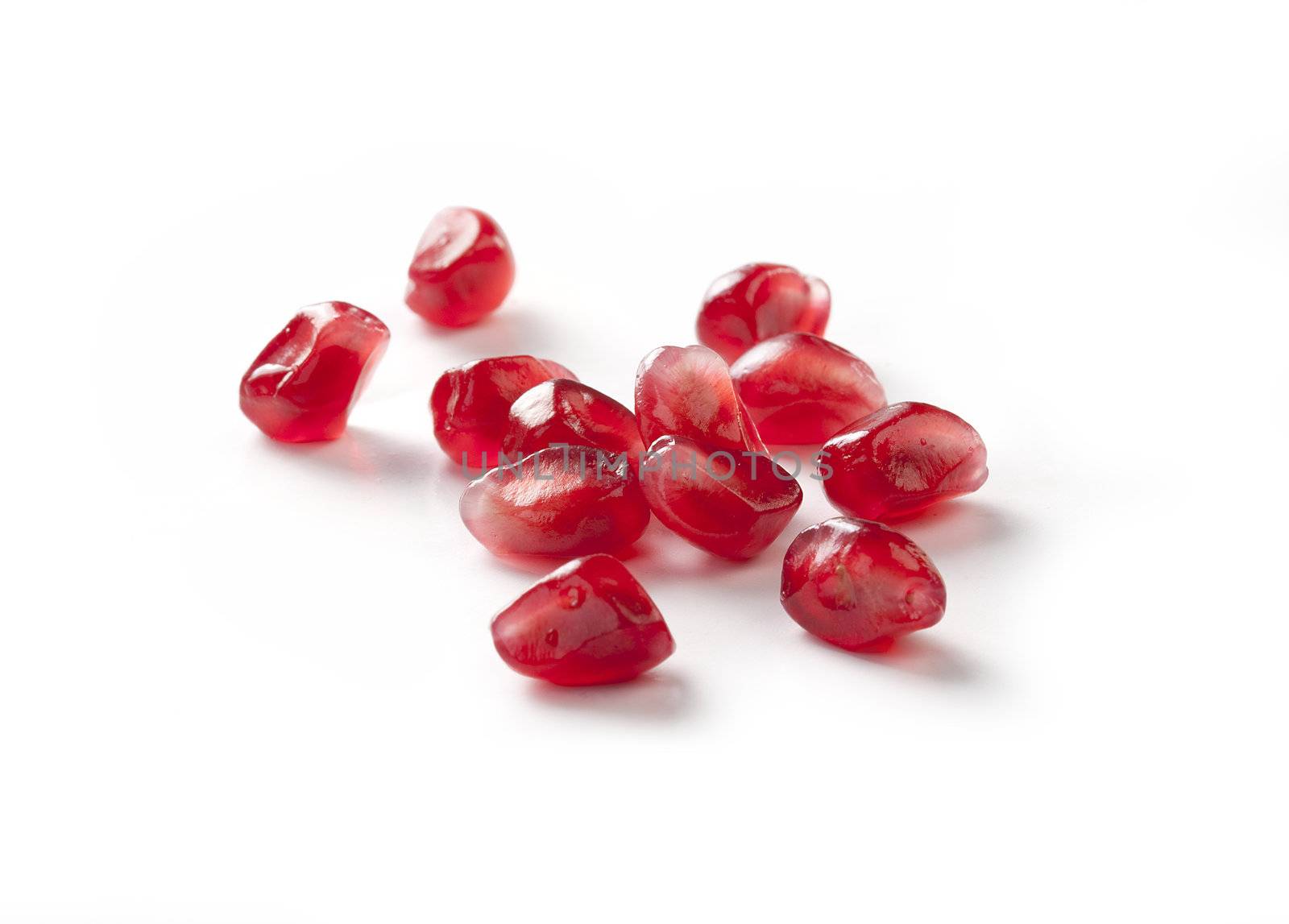 Handful of red seeds of pomegranate on the white background
