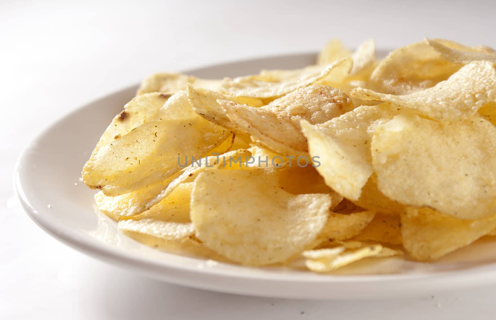 Handful of potato chips on the white plate