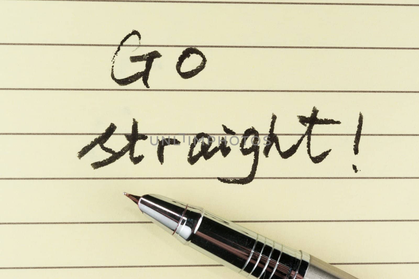 Go straight words written on lined paper with a pen on it