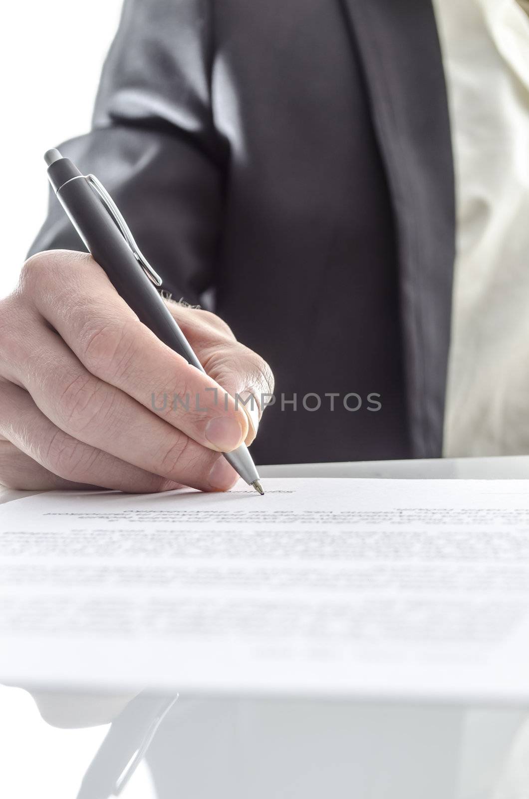 Closeup of a businessman's hand signing a contract on a white desk with reflection.