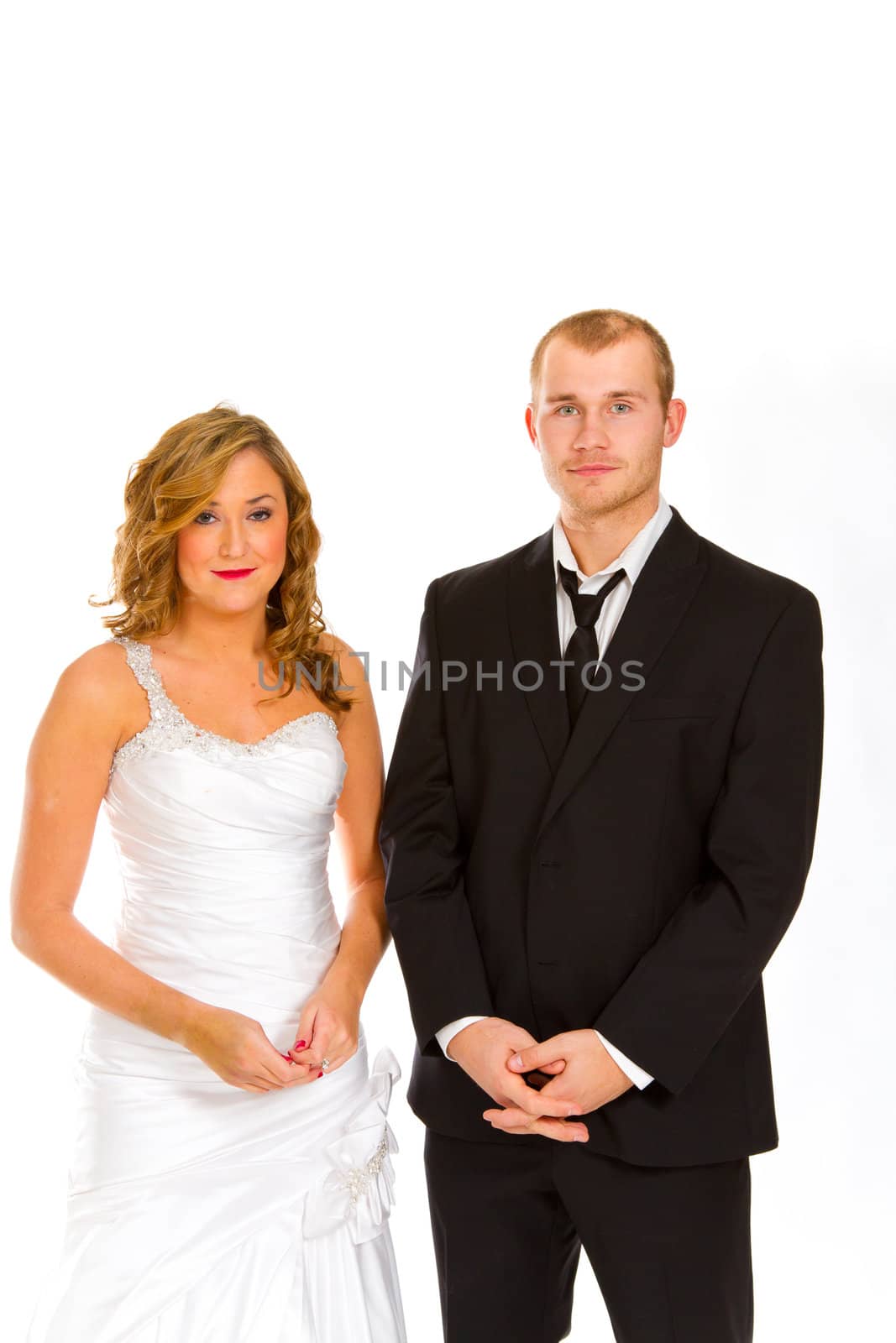 A beautiful bride and a handsome groom are isolated against a white background in the studio to create this bridal wedding portrait.