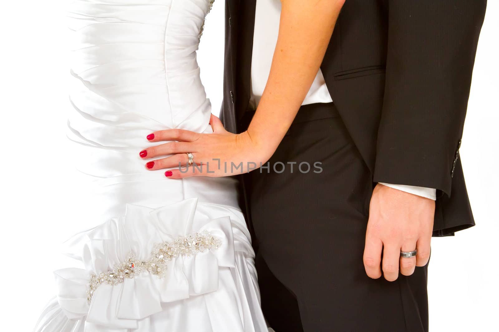 A bride and groom portrait showing only their bodies and their hands against a white background. You can see the wedding rings on the fingers.
