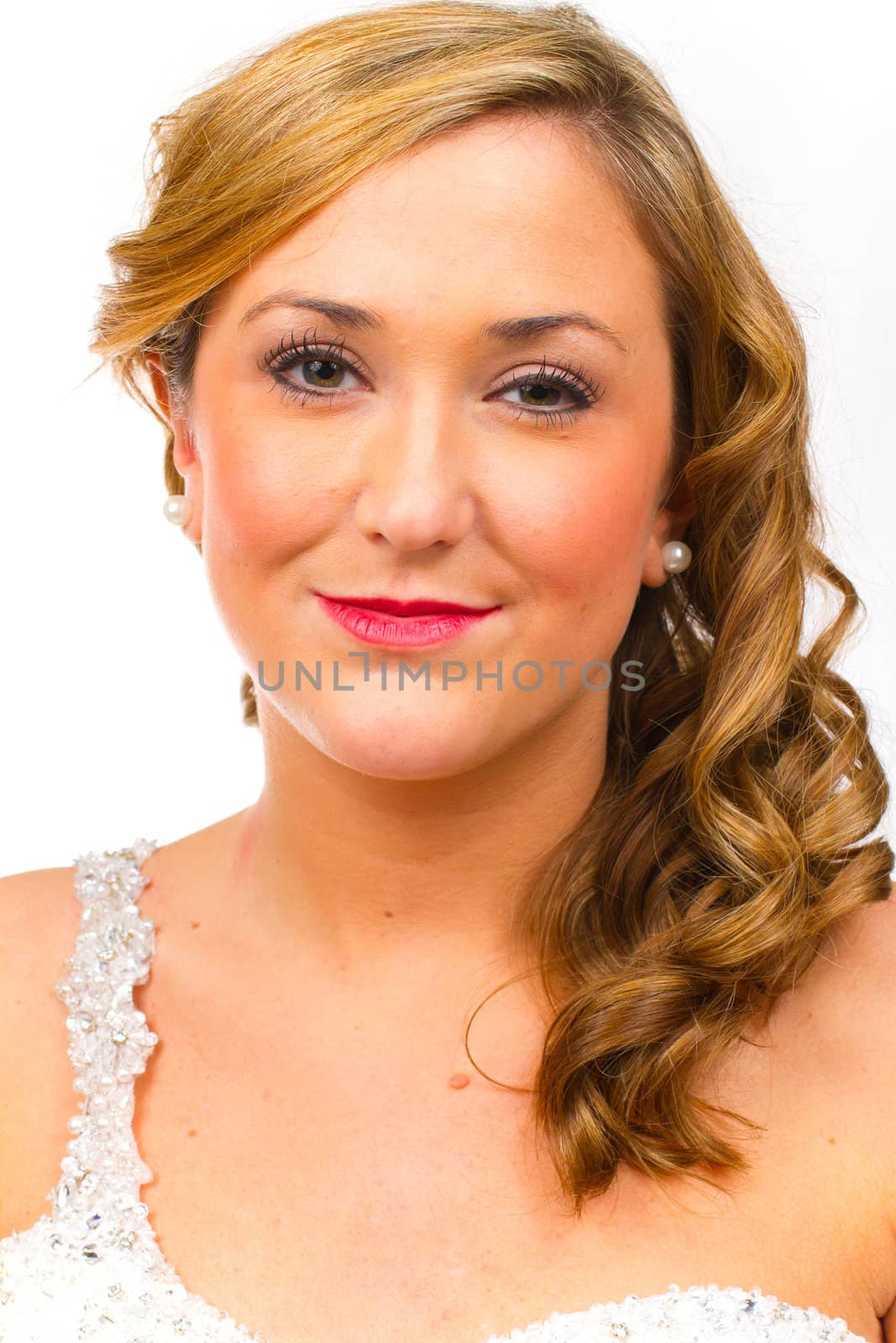 An isolated portrait of a beautiful brunette bride in the studio against a white background with her in her wedding dress.