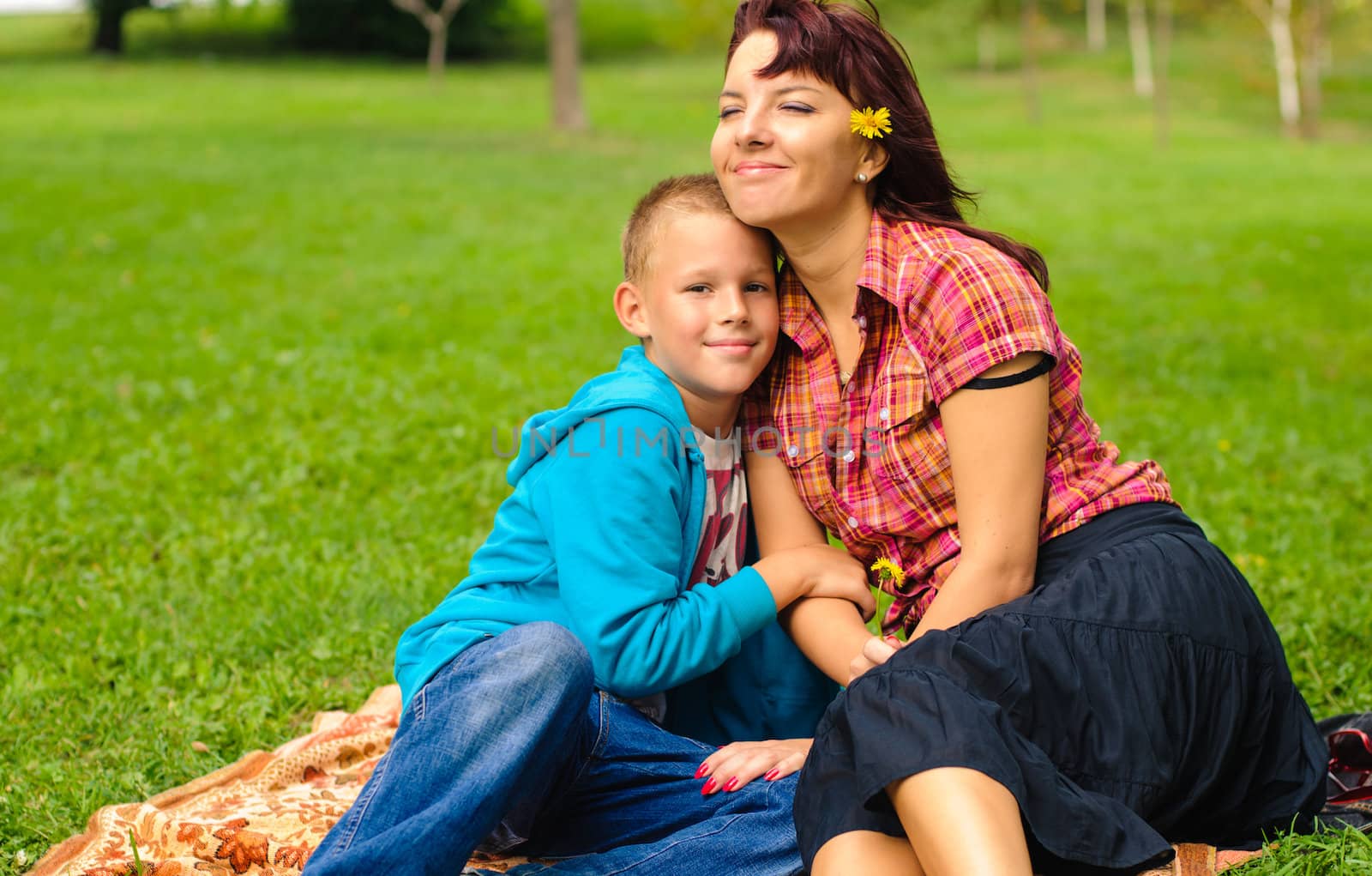 Mother and son play outside on field in the park