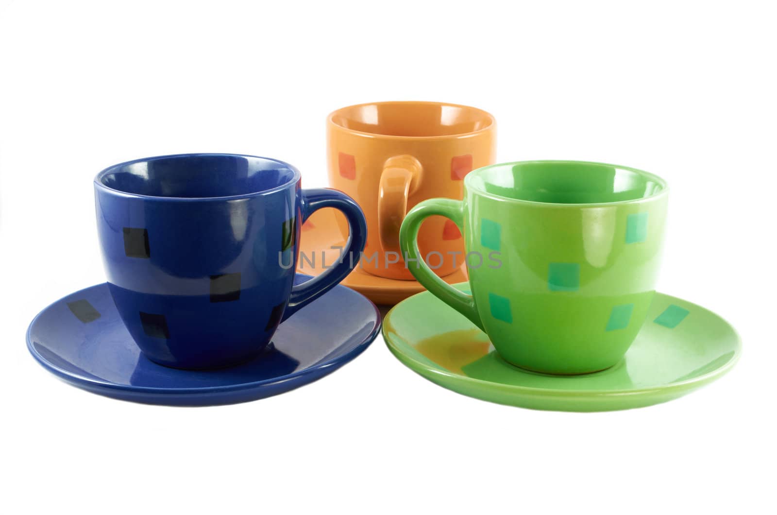 Colorful ceramic cups for tea on a saucer isolated on white background