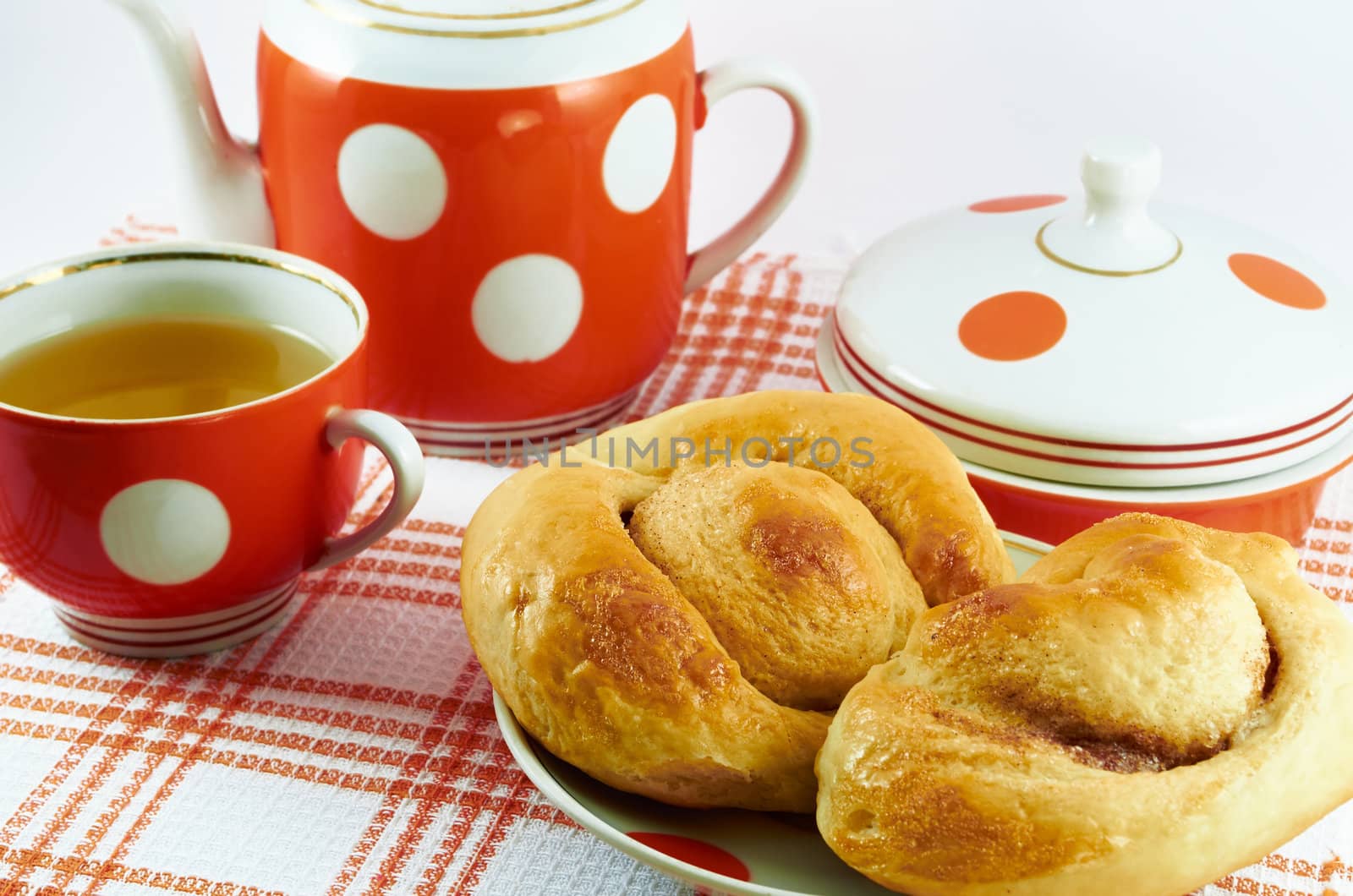 Rubicund delicious homemade cakes on a plate and cup of tea on a background of tea set
