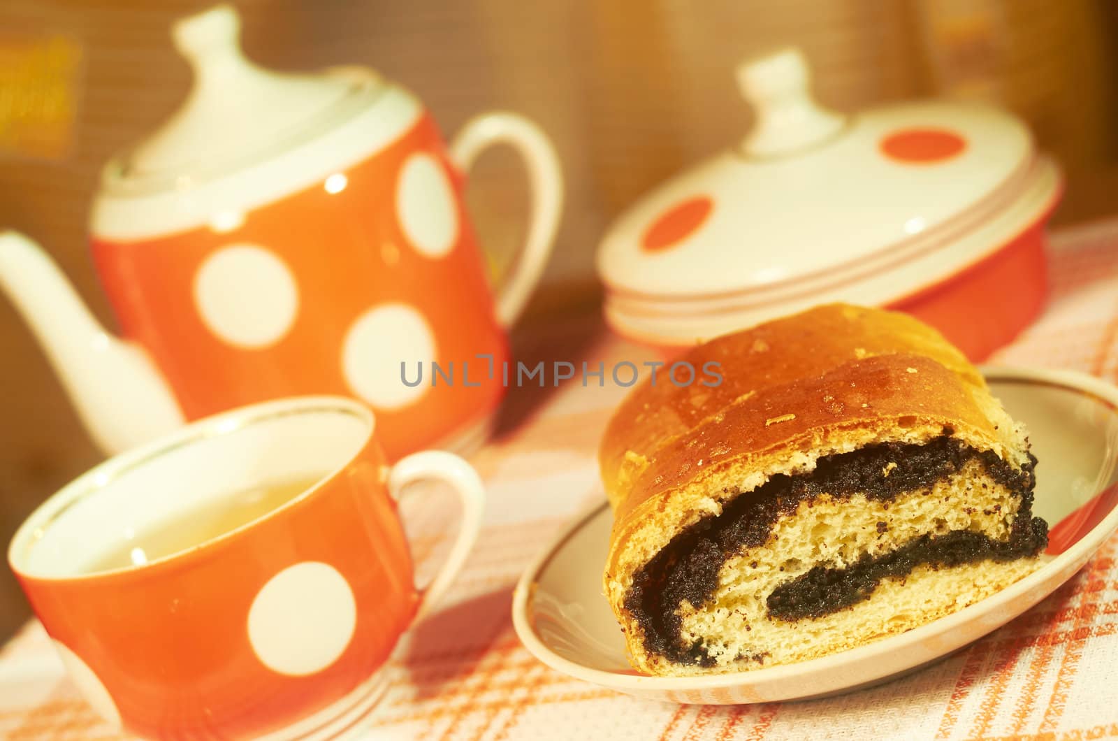 Homemade pie with poppy seeds on a background of tea set
