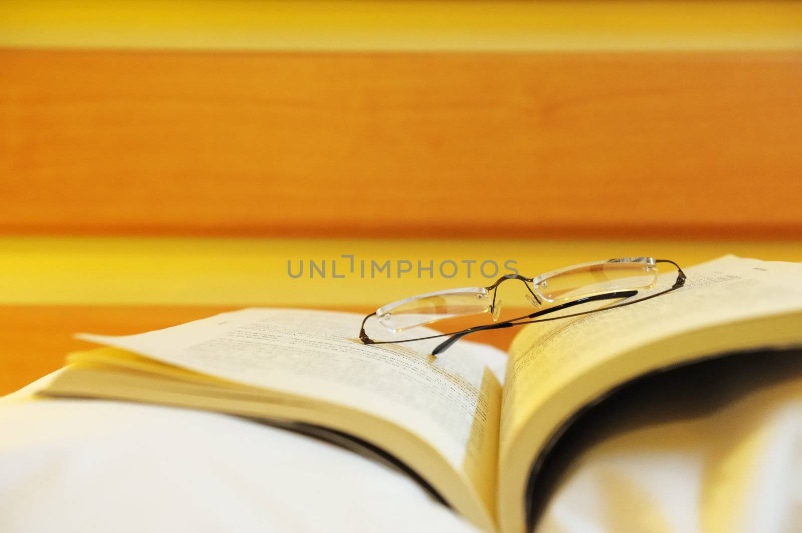 Book and glasses on the bed