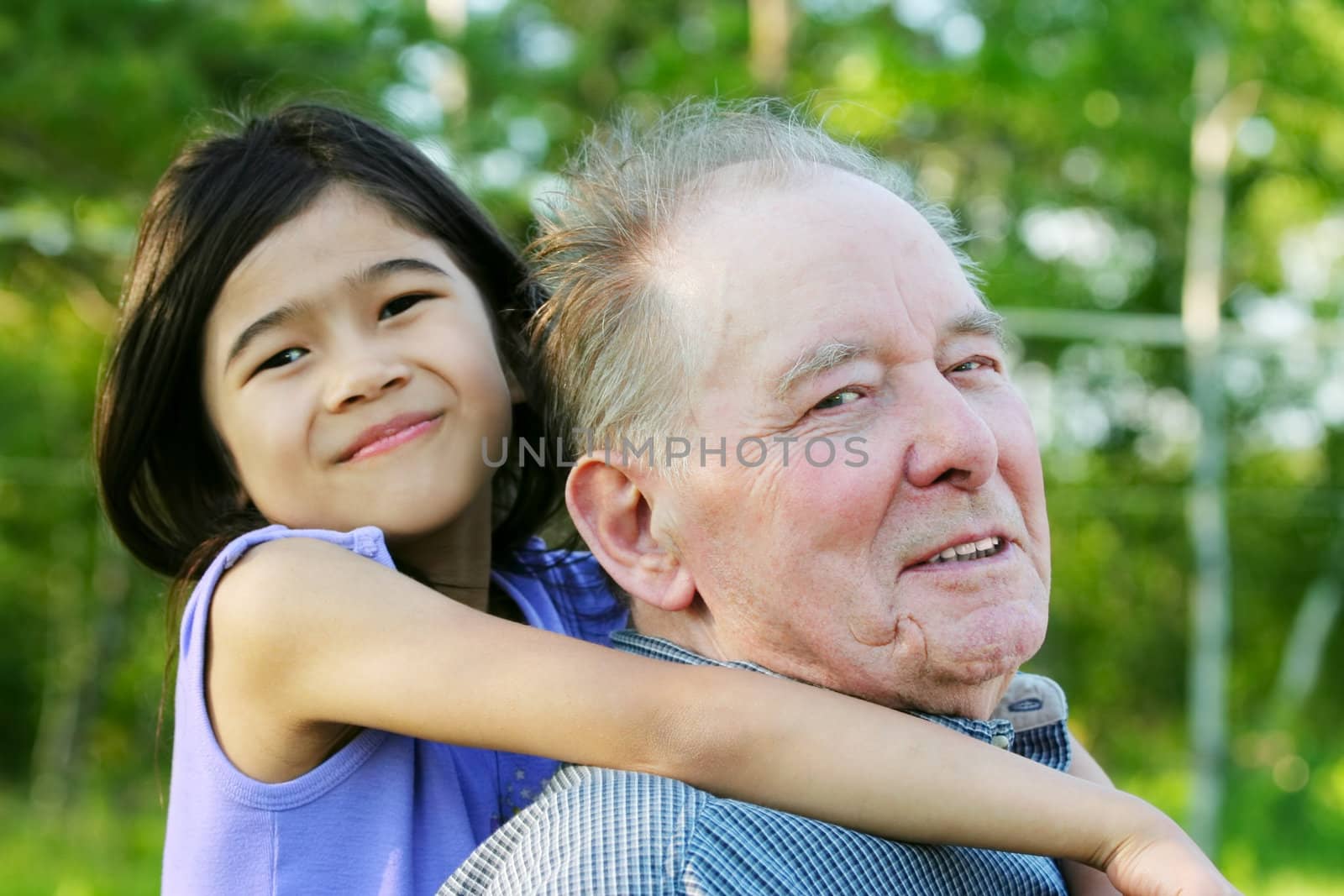 Little asian  girl hugging her caucasian grandfather outdoors, diversity