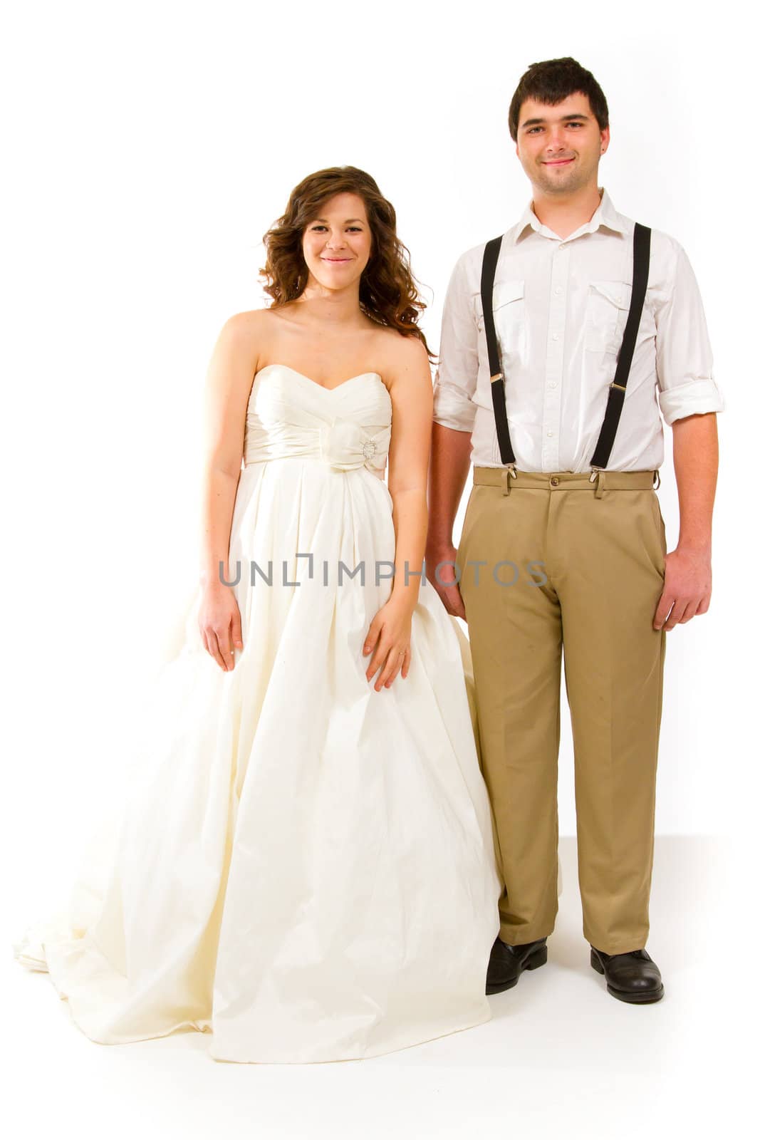 An attractive woman and her handsome husband wear their wedding attire in the studio agains an isolated white background.