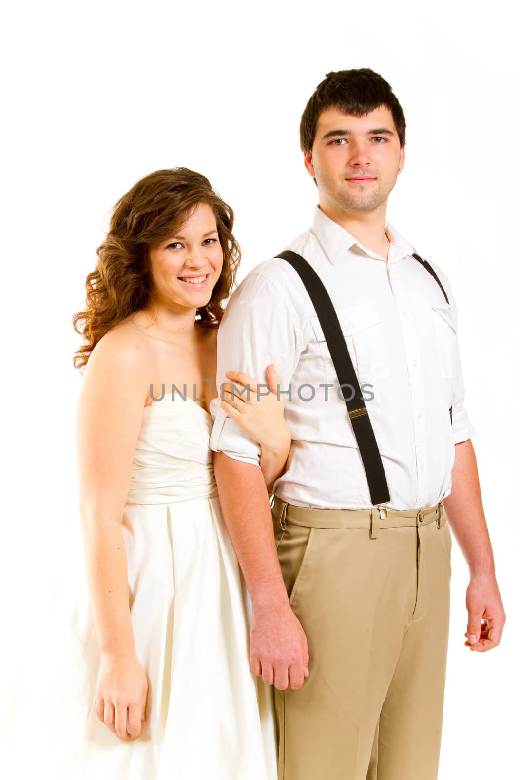 An attractive woman and her handsome husband wear their wedding attire in the studio agains an isolated white background.