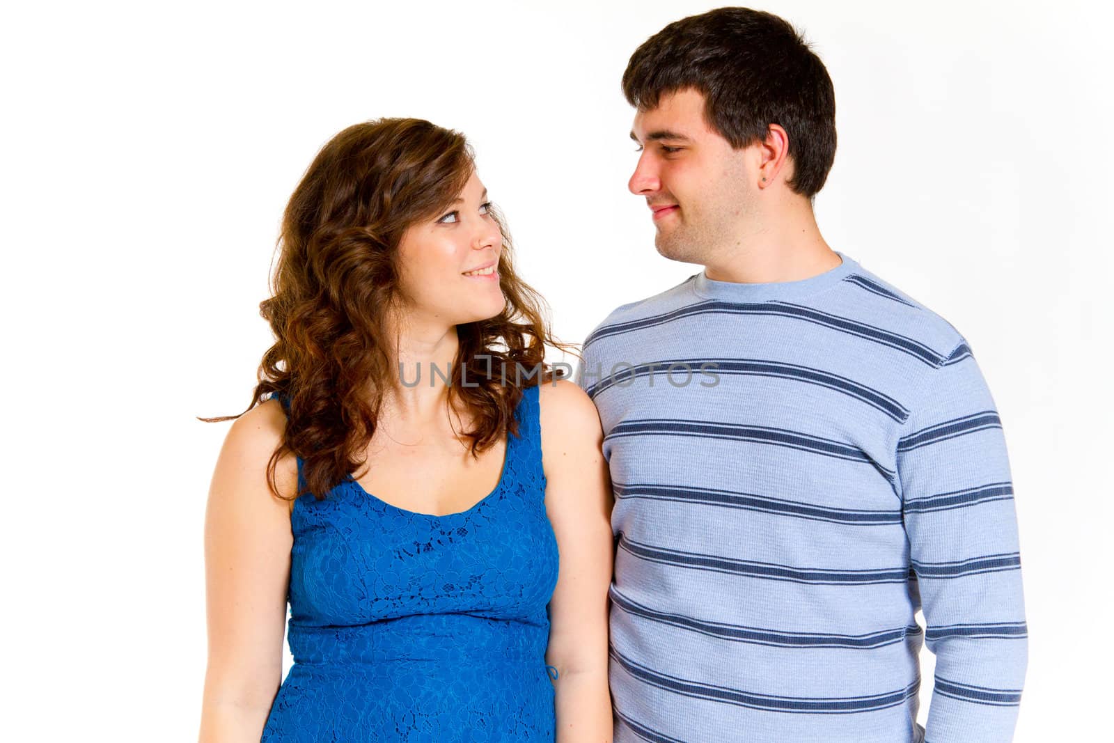 A white background studio shot of a young couple in blue fashionable stylish outfits.