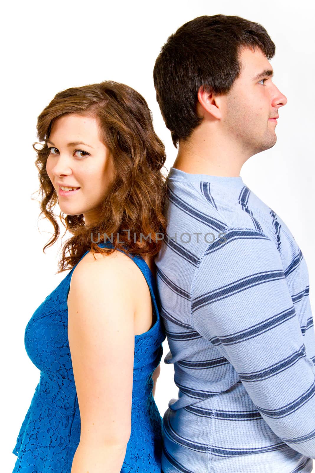 A white background studio shot of a young couple in blue fashionable stylish outfits.