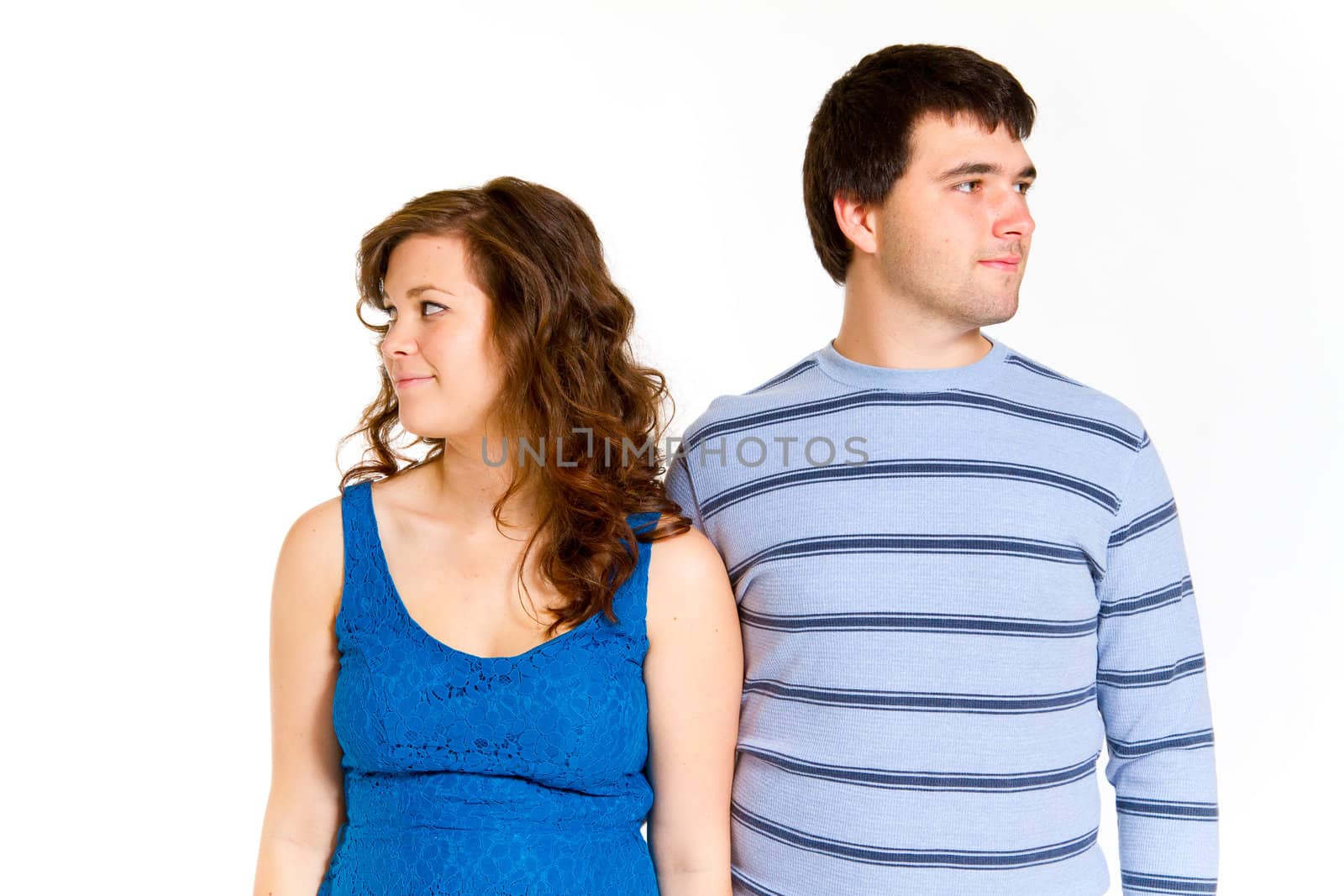 A white background studio shot of a young couple in blue fashionable stylish outfits.