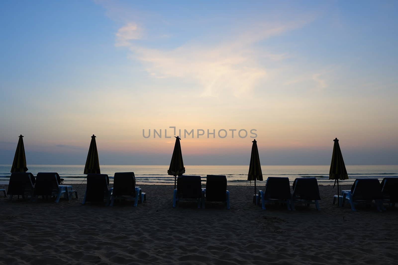 Beach landscape with a row of folded umbrella in Phuket Island, Thailand
