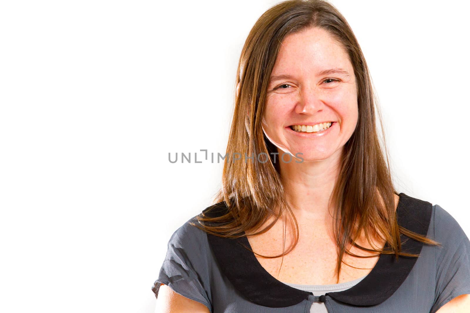 A pretty woman poses for a portrait in the studio against an isolated white background while wearing black and grey and looking happy.